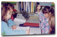 Sighted and blind students working in a group—blind student raising her hand